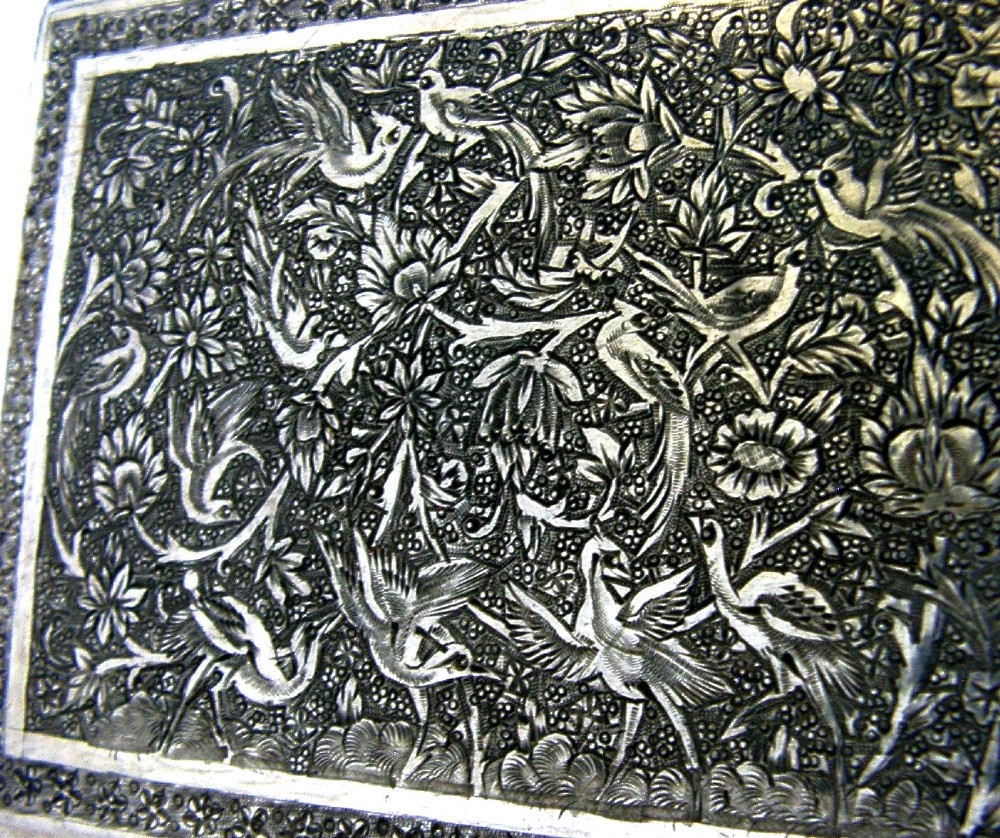 A rectangular solid silver cigarette case featuring hand-chased relief work depicting birds and floral motifs surrounded by a decorative border. View II
