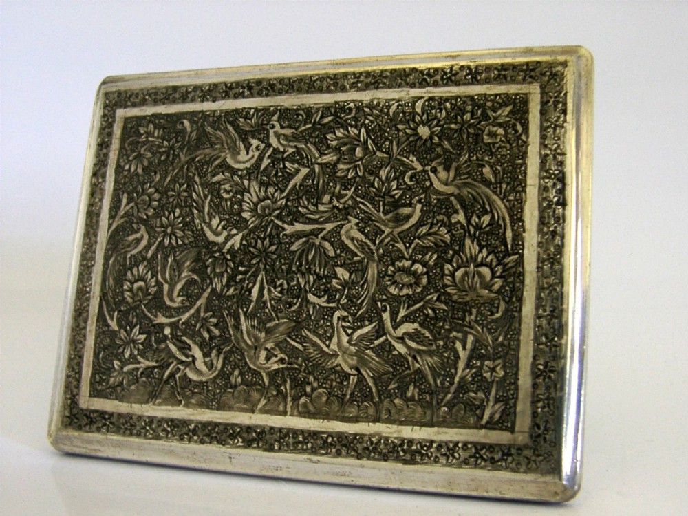 A rectangular solid silver cigarette case featuring hand-chased relief work depicting birds and floral motifs surrounded by a decorative border. View IV