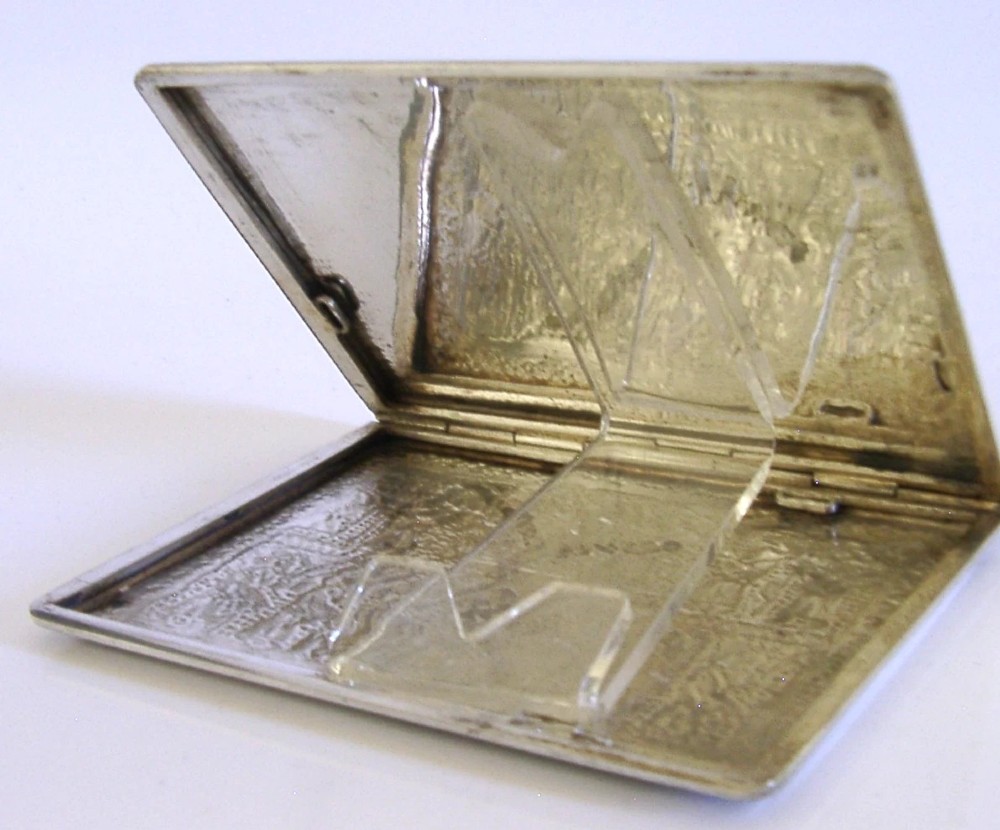 A rectangular solid silver cigarette case featuring hand-chased relief work depicting birds and floral motifs surrounded by a decorative border. View V