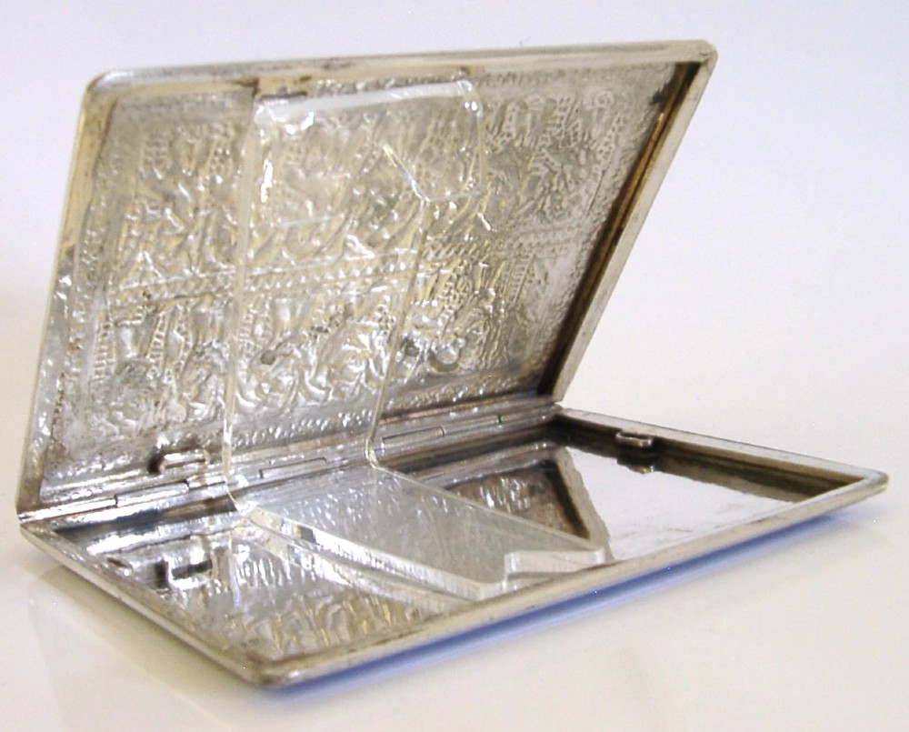 A rectangular solid silver cigarette case featuring hand-chased relief work depicting birds and floral motifs surrounded by a decorative border. View VI