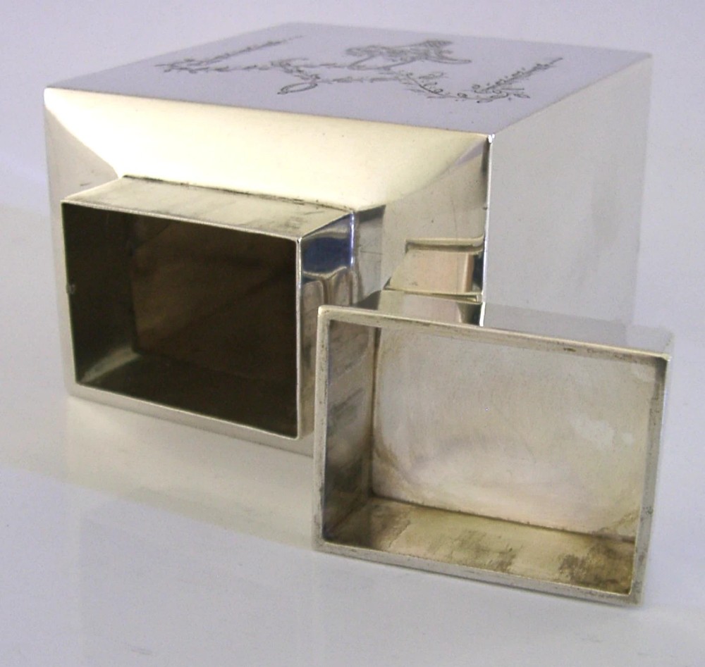 An antique Edwardian rectangular sterling silver tea caddy decorated with delicate engraved floral swags and a central flower basket, topped with a square cap lid. View VII