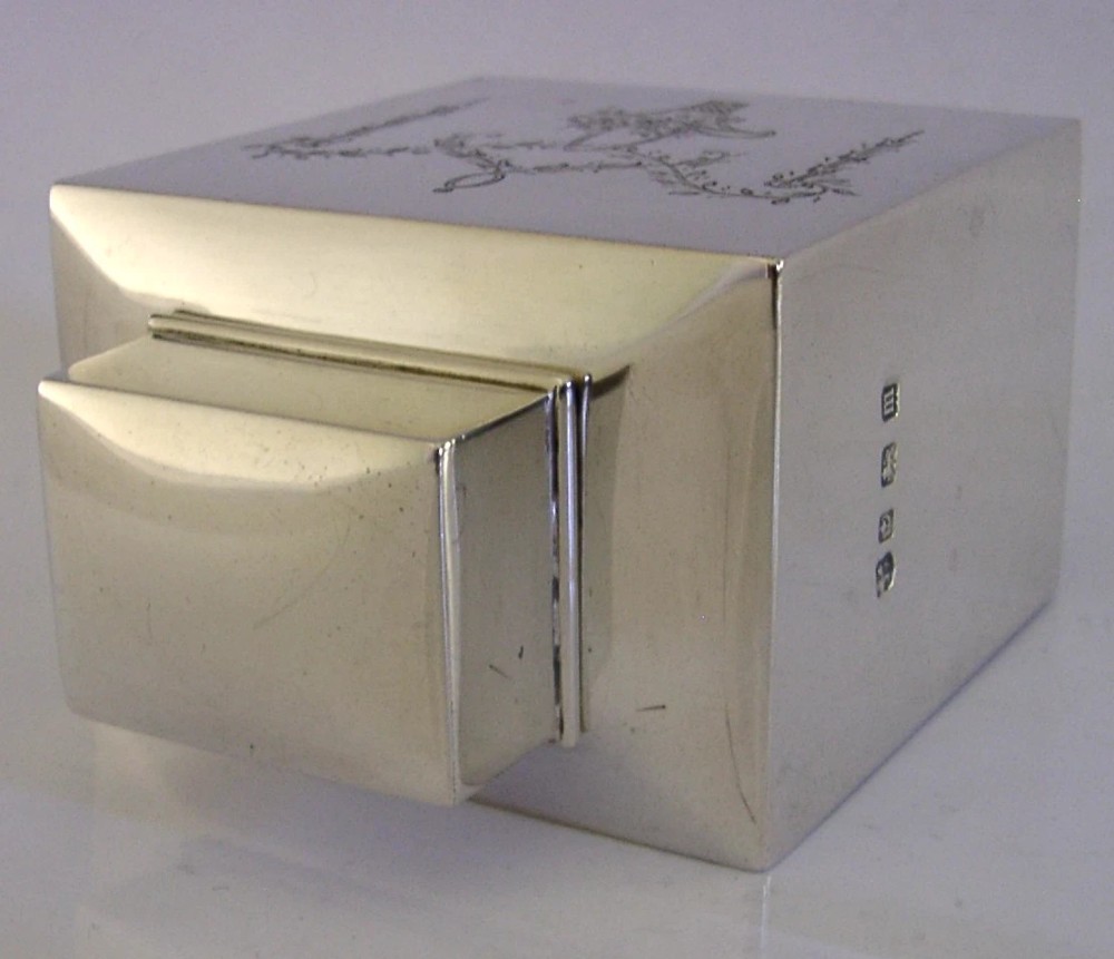 An antique Edwardian rectangular sterling silver tea caddy decorated with delicate engraved floral swags and a central flower basket, topped with a square cap lid. View VIII