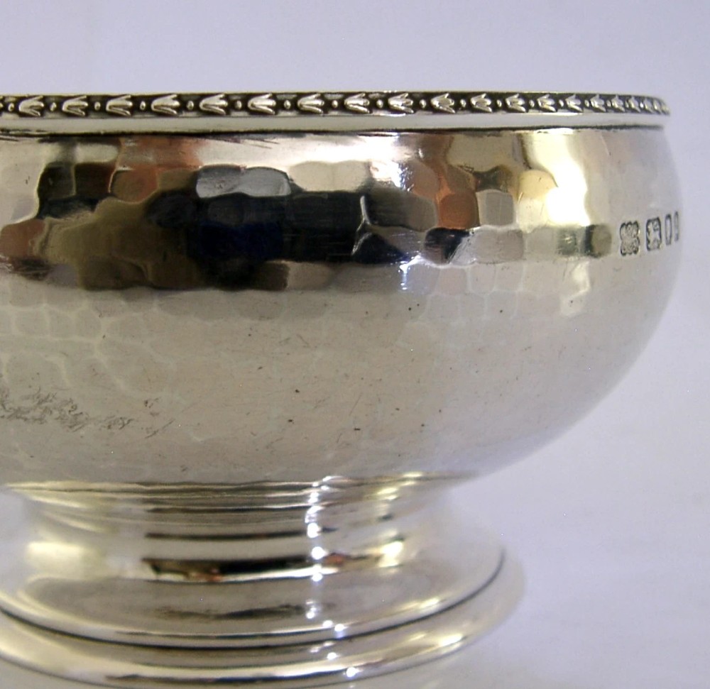 A planished sterling silver bowl featuring a hand-hammered finish, patterned rim, pedestal base, and British hallmarks stamped on the side. View II