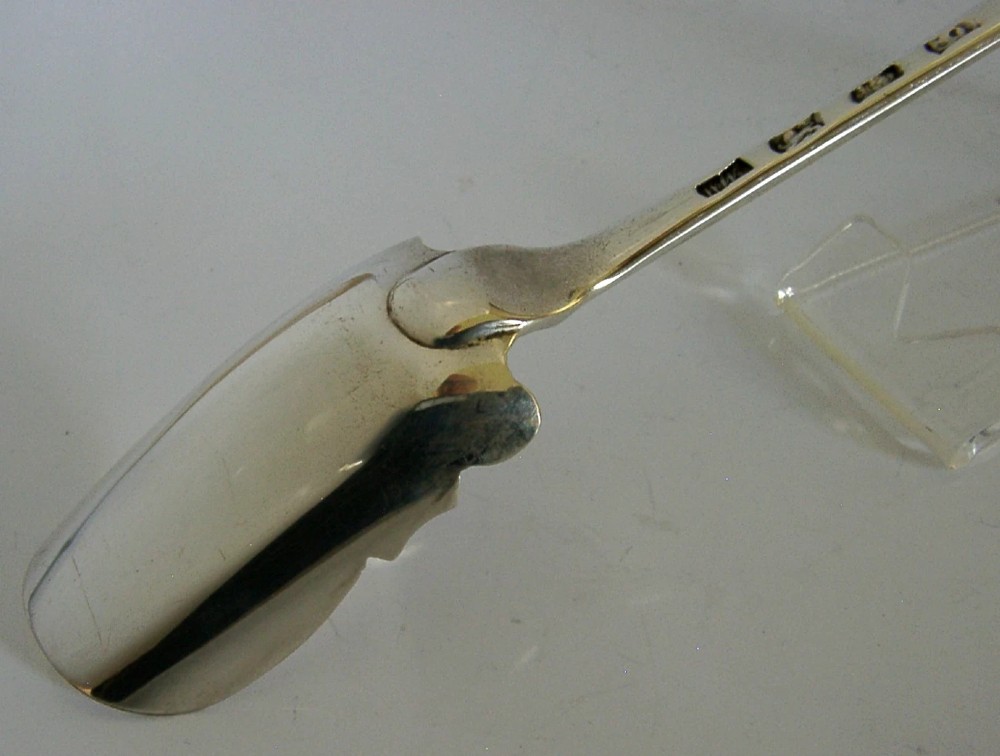 A solid sterling silver George III Stilton cheese scoop with a long tapered handle and a curved trough-shaped blade. View IV