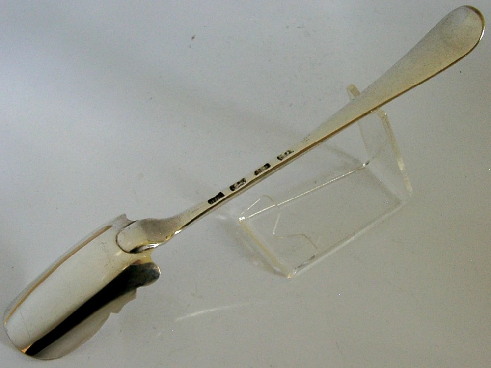 A solid sterling silver George III Stilton cheese scoop with a long tapered handle and a curved trough-shaped blade. View V