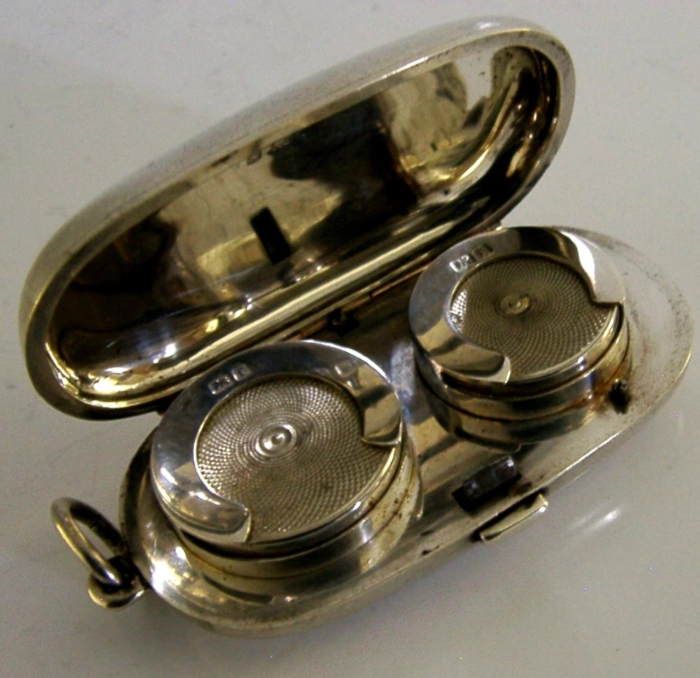 An open Edwardian sterling silver double sovereign case with gold hinge detail showing two spring-loaded coin compartments. View III