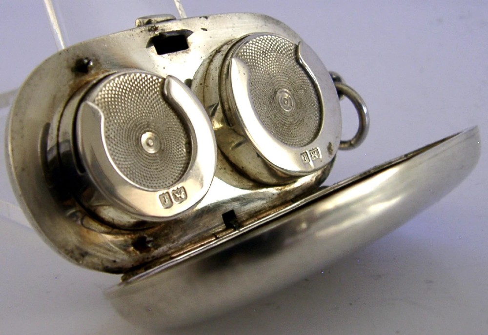 An open Edwardian sterling silver double sovereign case with gold hinge detail showing two spring-loaded coin compartments. View IV