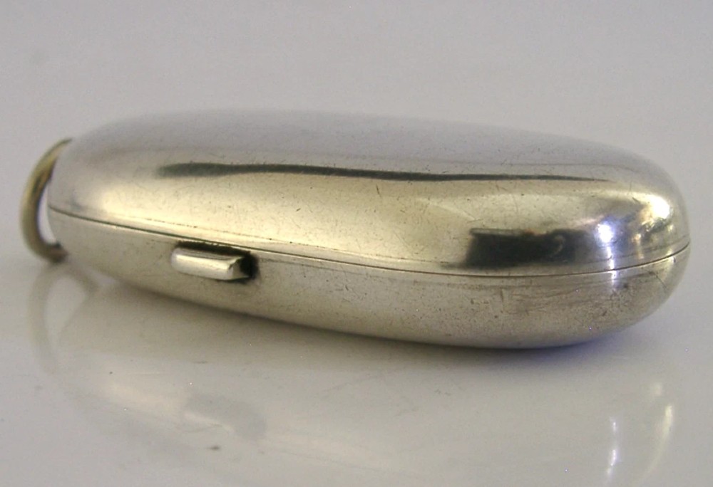 An open Edwardian sterling silver double sovereign case with gold hinge detail showing two spring-loaded coin compartments. View V