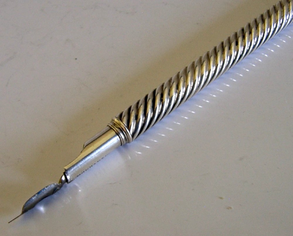 A Victorian sterling silver dip pen featuring a spiral fluted barrel and a metal writing nib. View IV