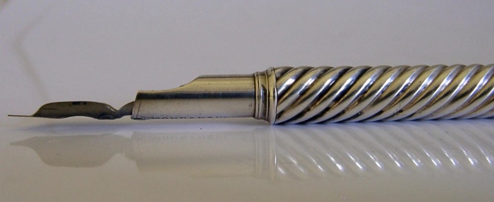 A Victorian sterling silver dip pen featuring a spiral fluted barrel and a metal writing nib. View V