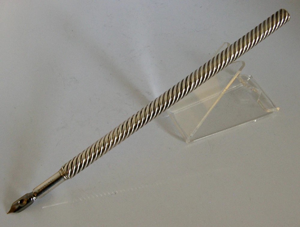 A Victorian sterling silver dip pen featuring a spiral fluted barrel and a metal writing nib. View VI