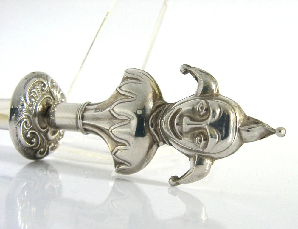 An Edwardian sterling silver sealing wax holder topped with a cast jester bust wearing a cap and bells. View V