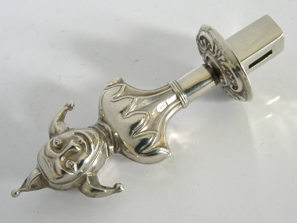 An Edwardian sterling silver sealing wax holder topped with a cast jester bust wearing a cap and bells. View VIII