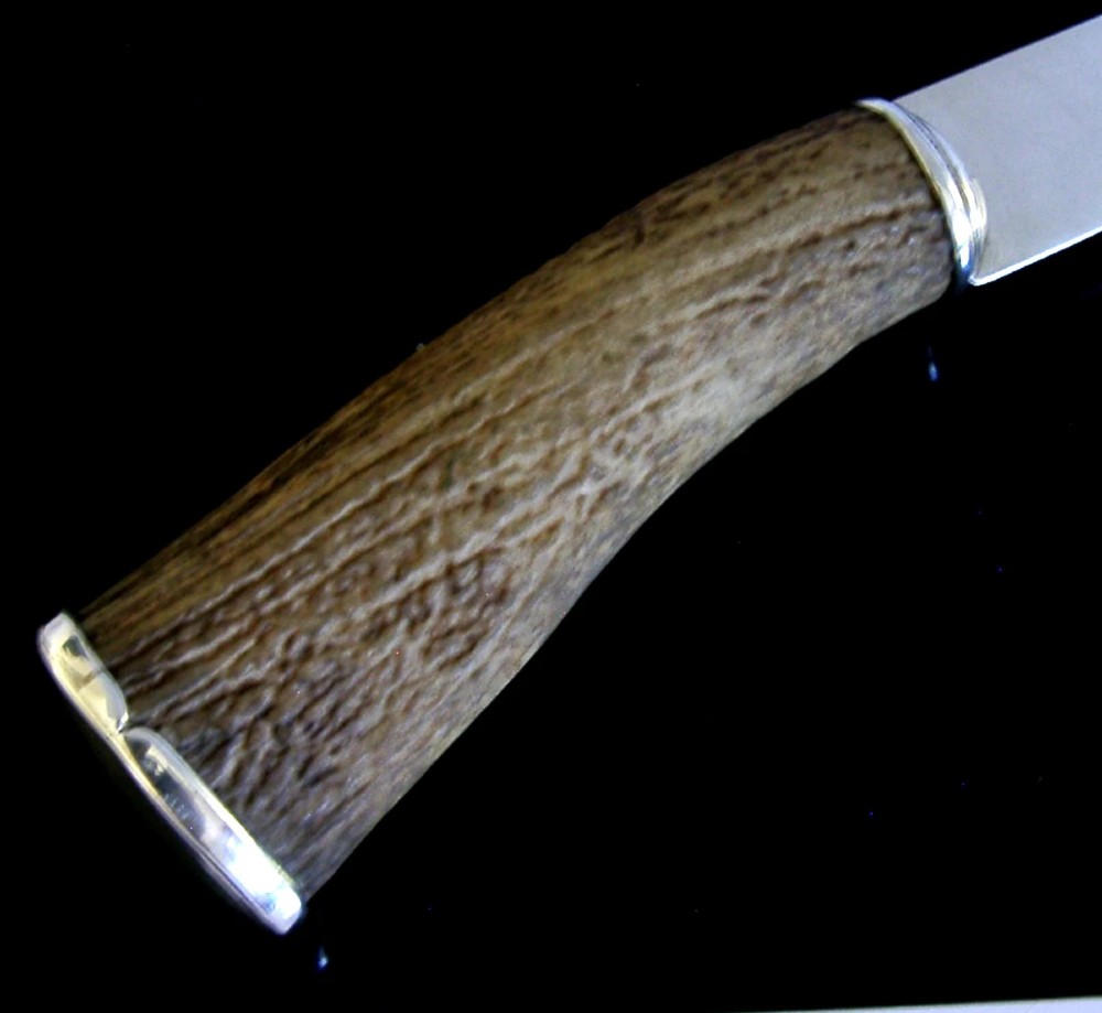 A Scottish provincial sterling silver page turner featuring a smooth silver blade mounted to a natural curved horn handle with a silver end cap. View III