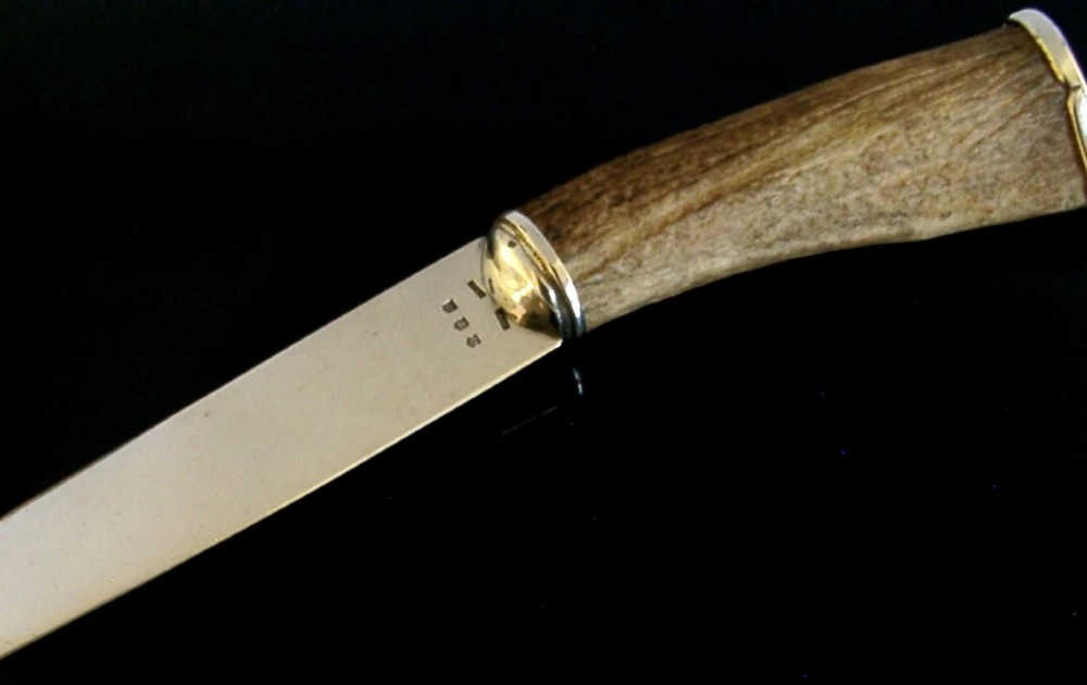 A Scottish provincial sterling silver page turner featuring a smooth silver blade mounted to a natural curved horn handle with a silver end cap. View IV
