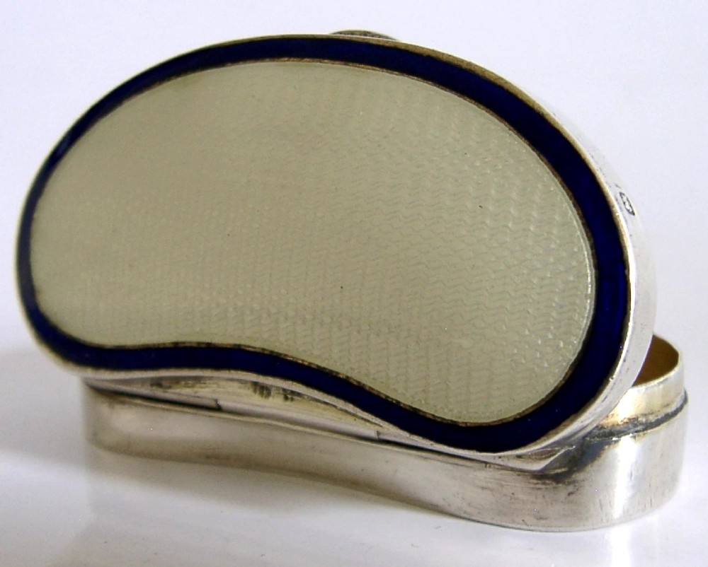 An Edwardian kidney-shaped sterling silver box featuring a white guilloche enamelled lid bordered with deep royal blue enamel.