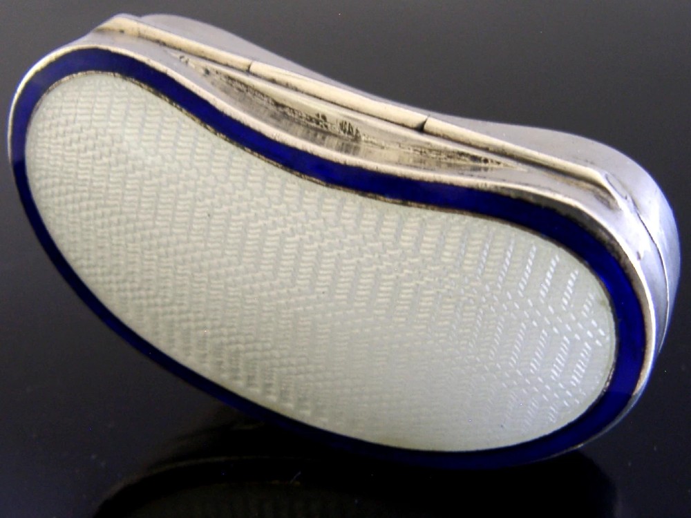An Edwardian kidney-shaped sterling silver box featuring a white guilloche enamelled lid bordered with deep royal blue enamel. View IV