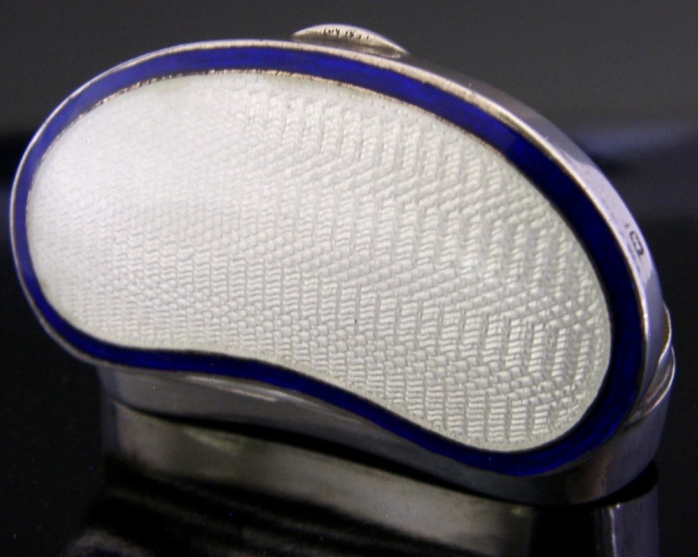 An Edwardian kidney-shaped sterling silver box featuring a white guilloche enamelled lid bordered with deep royal blue enamel. View VI