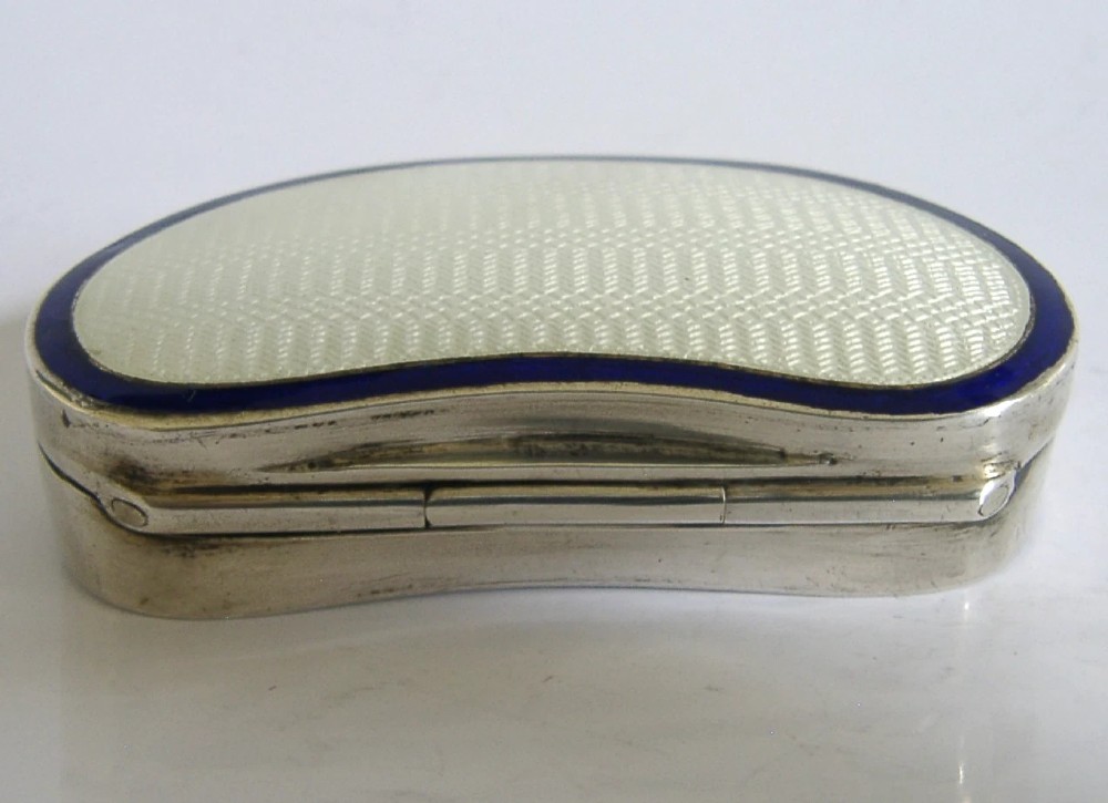 An Edwardian kidney-shaped sterling silver box featuring a white guilloche enamelled lid bordered with deep royal blue enamel. View VII