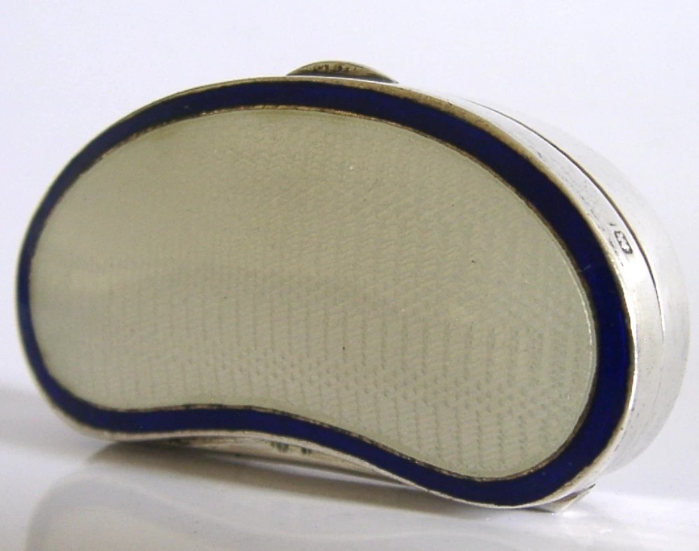 An Edwardian kidney-shaped sterling silver box featuring a white guilloche enamelled lid bordered with deep royal blue enamel. View XII
