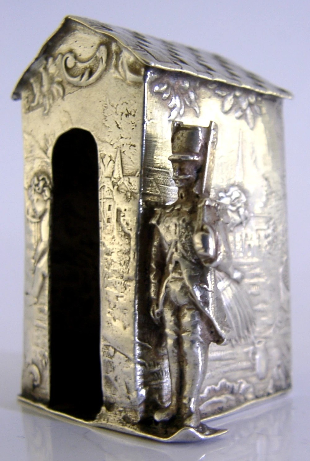 An antique Hanau silver miniature sentry post featuring a uniformed soldier guard standing beside an arched entryway with chased decorative detailing. View II