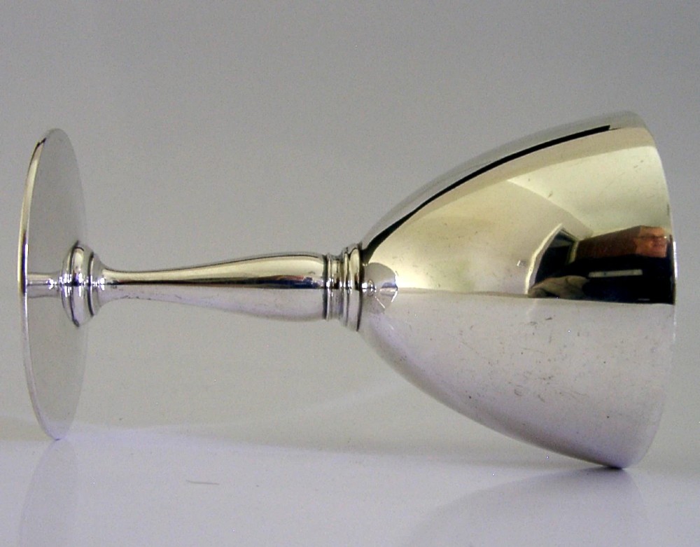 An Art Deco sterling silver cocktail goblet featuring a polished surface, a conical bowl, a turned stem, and a flat circular base. View V