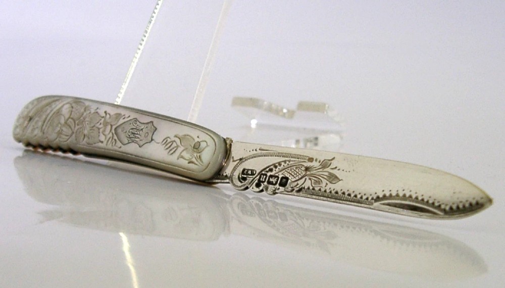 An Edwardian folding fruit knife with a carved mother-of-pearl handle and engraved silver shield cartouche. View IV