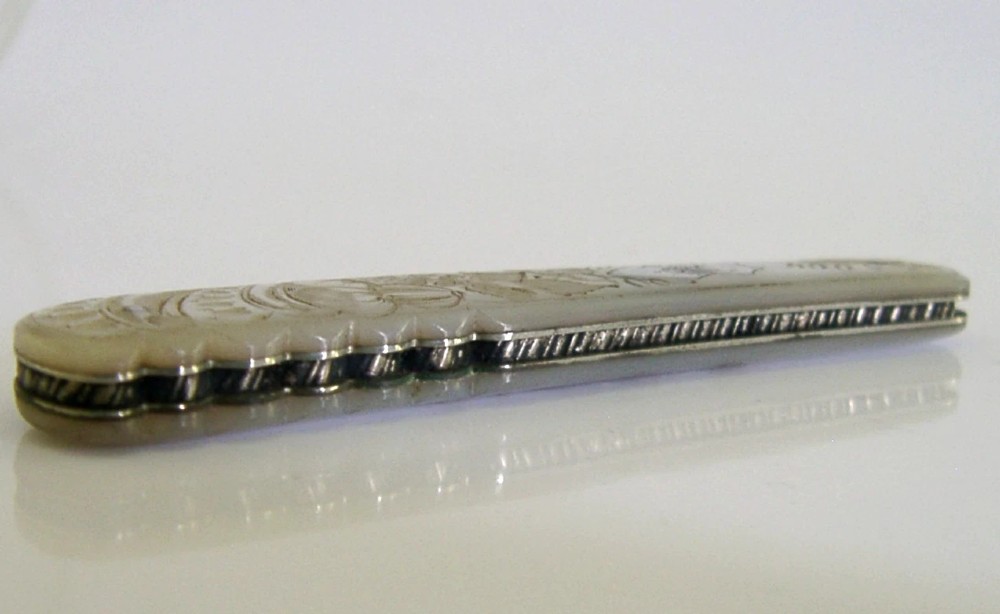 An Edwardian folding fruit knife with a carved mother-of-pearl handle and engraved silver shield cartouche. View V