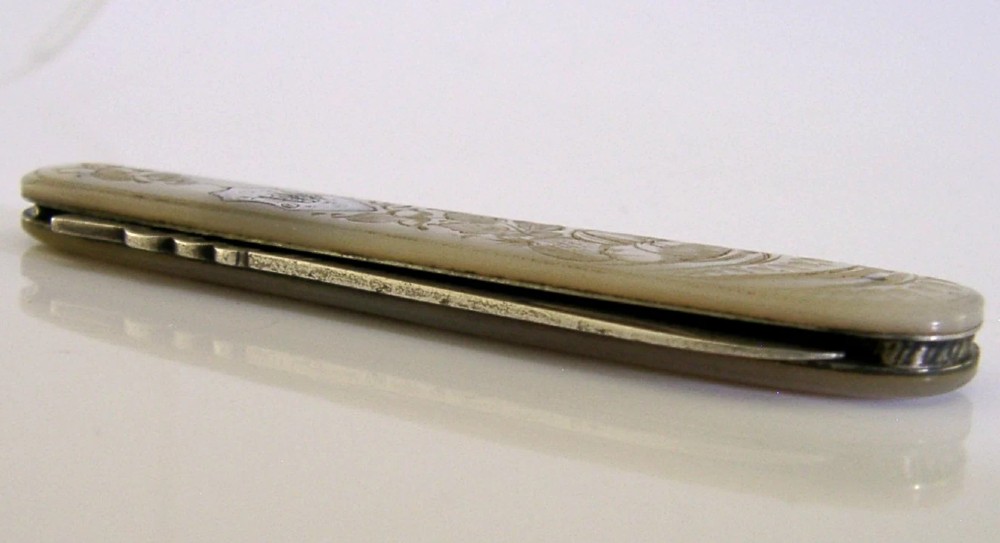 An Edwardian folding fruit knife with a carved mother-of-pearl handle and engraved silver shield cartouche. View VIII