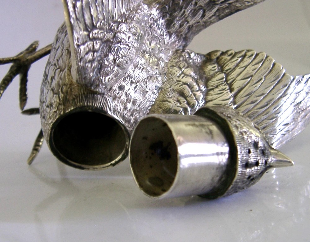 A solid silver pepper pot finely chased in the detailed form of a bird chick with outstretched wings. View XI
