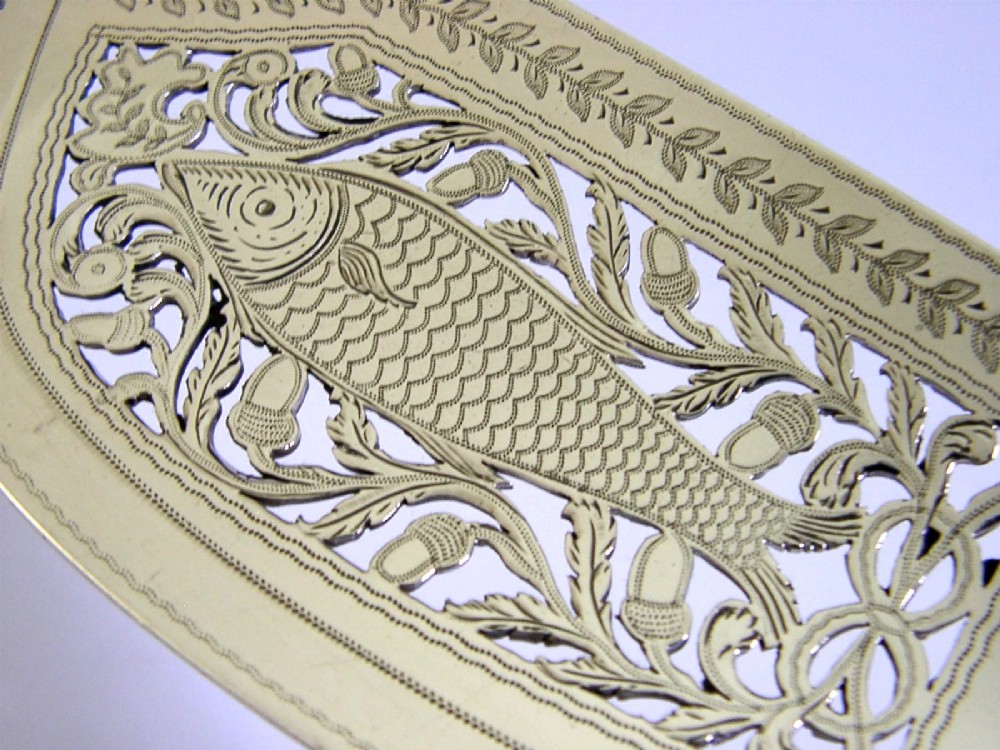 A George IV sterling silver fish slice featuring a hand-pierced central fish motif with leaf engraving and a contoured handle. View II