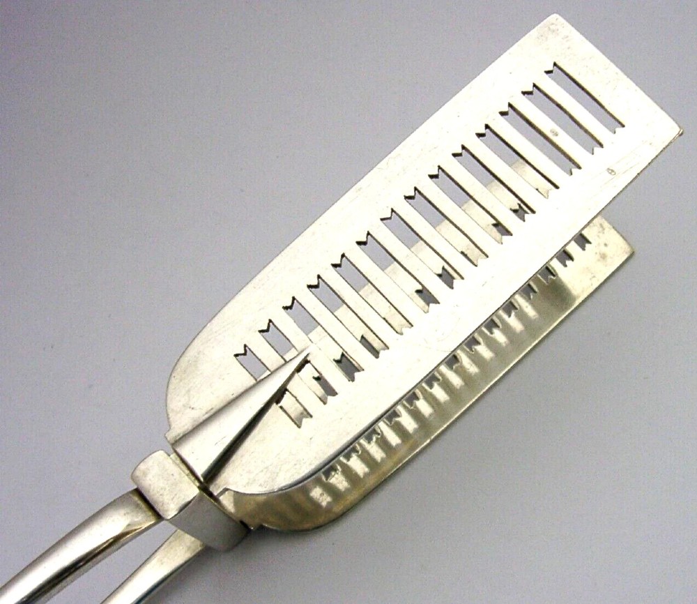 Victorian sterling silver serving tongs featuring slotted rectangular blades and a spring-hinged handle stamped with hallmarks. View III