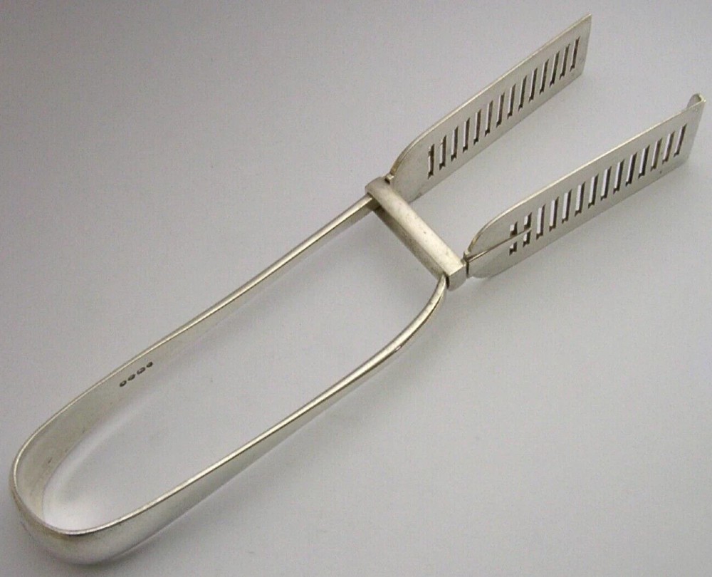 Victorian sterling silver serving tongs featuring slotted rectangular blades and a spring-hinged handle stamped with hallmarks. View VII