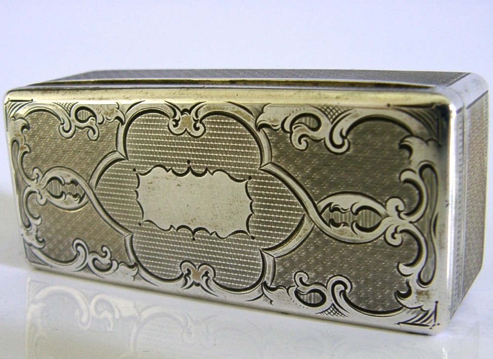 An antique rectangular Austro-Hungarian solid silver box featuring intricate engraved scrollwork and an open hinged lid displaying a gilt interior. View II