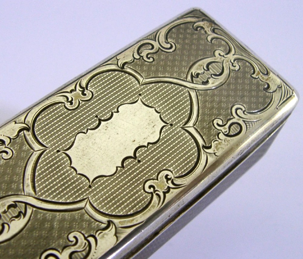 An antique rectangular Austro-Hungarian solid silver box featuring intricate engraved scrollwork and an open hinged lid displaying a gilt interior. View III