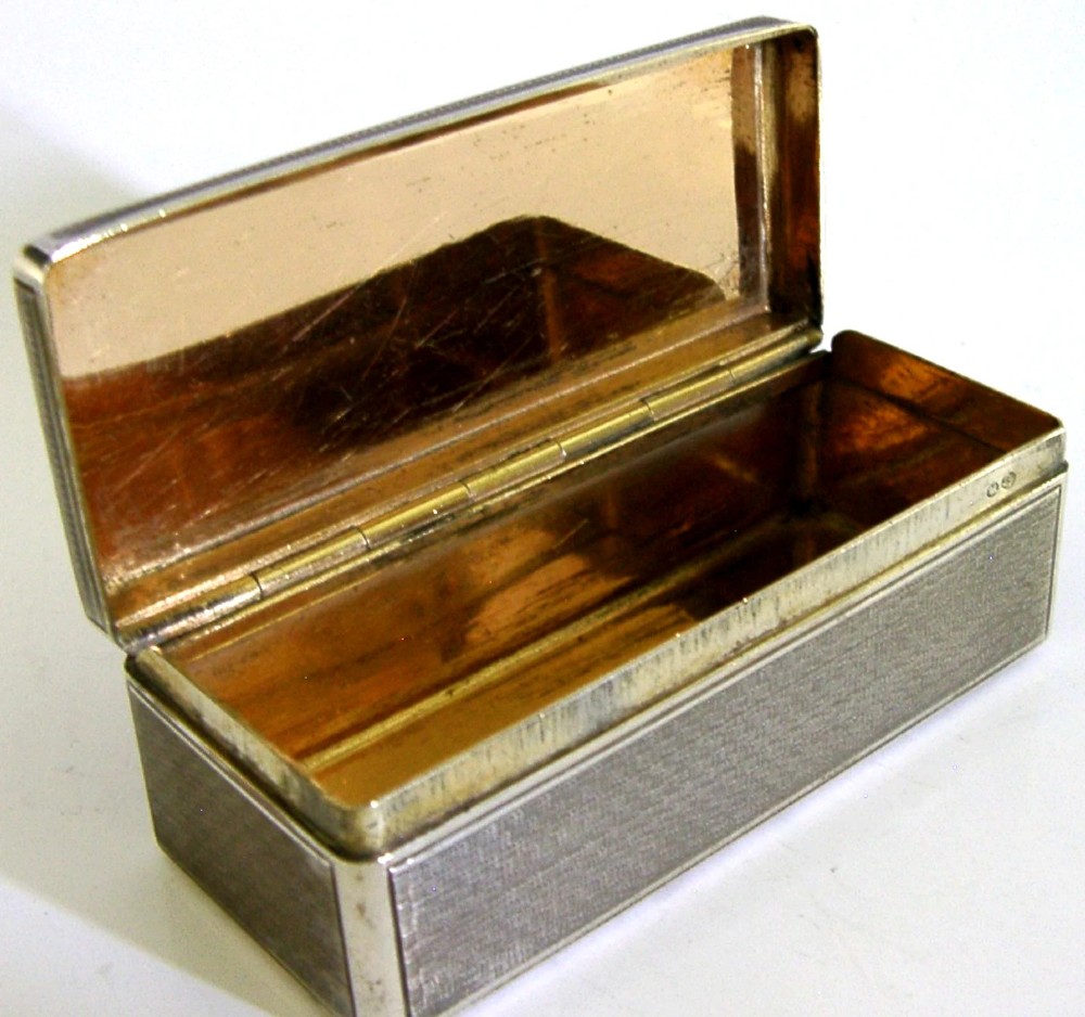 An antique rectangular Austro-Hungarian solid silver box featuring intricate engraved scrollwork and an open hinged lid displaying a gilt interior. View V