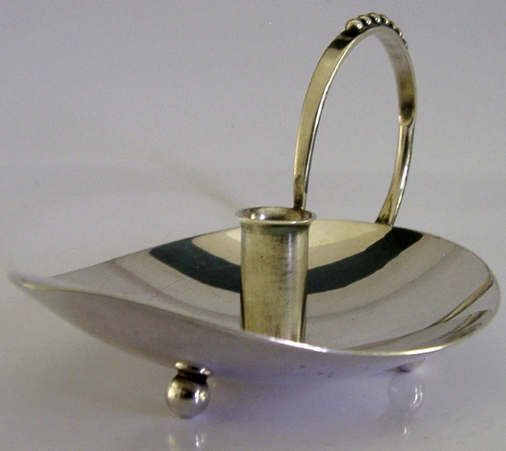 A sterling silver leaf-shaped chamberstick featuring a central candle socket and a looped handle accented with small silver spheres. View II