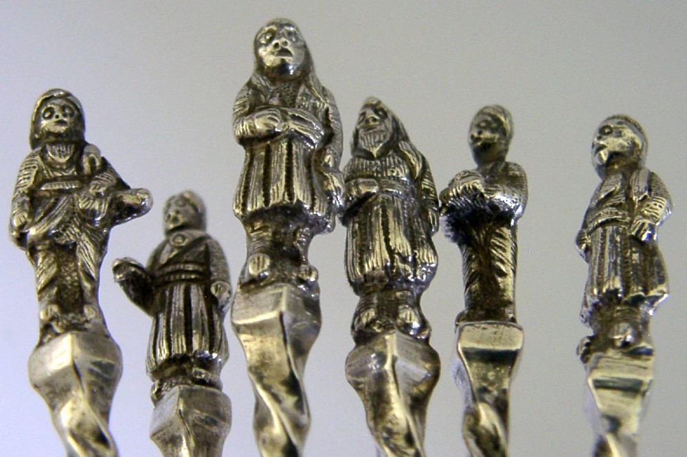 A set of six antique solid silver spoons featuring twisted stems, figural finials, and oval bowls. View IV
