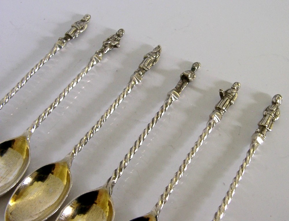 A set of six antique solid silver spoons featuring twisted stems, figural finials, and oval bowls. View V