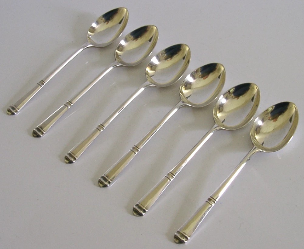 A set of six Art Deco sterling silver teaspoons arranged neatly inside a dark blue velvet-lined presentation case. View IV