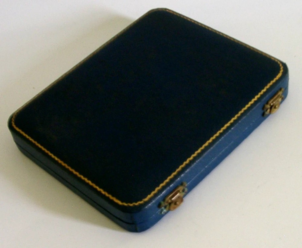 A set of six Art Deco sterling silver teaspoons arranged neatly inside a dark blue velvet-lined presentation case. View VI