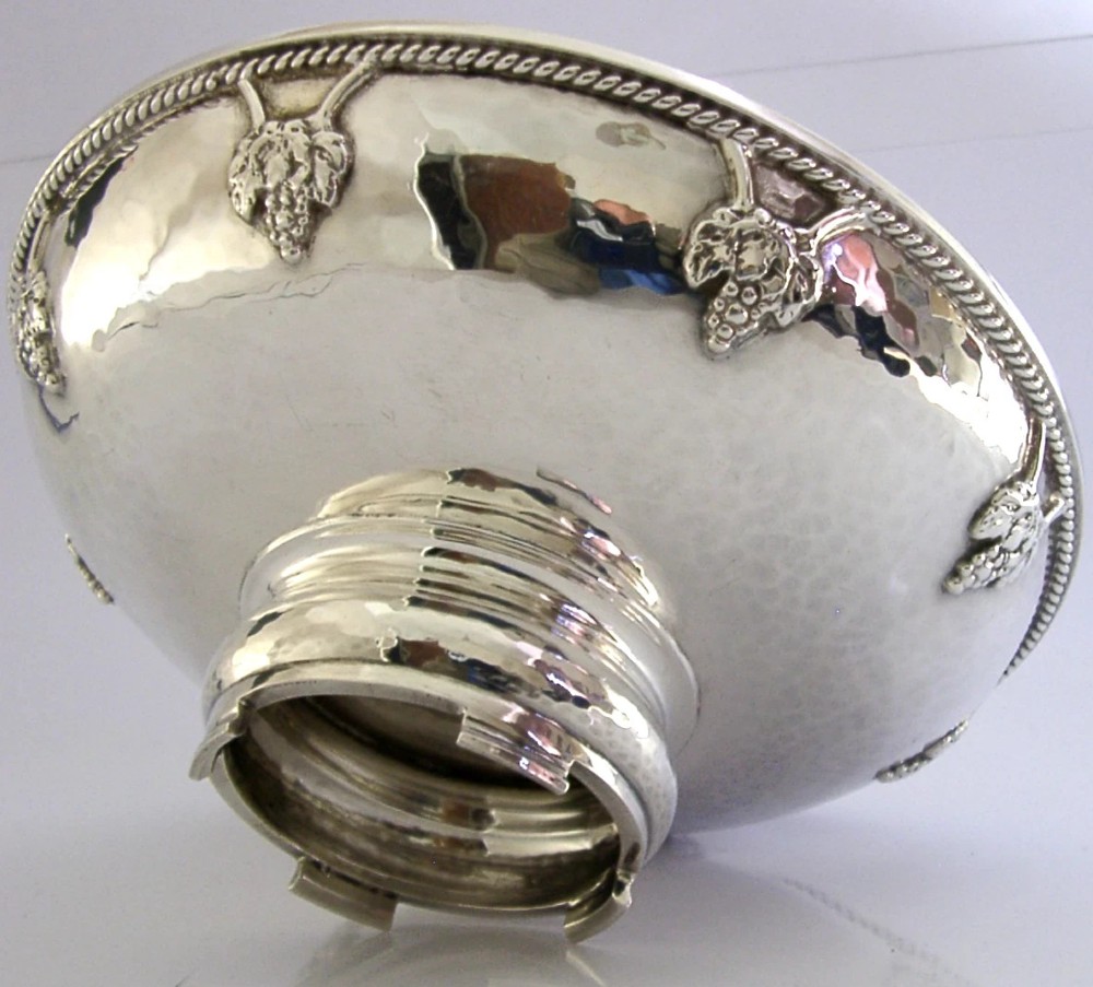A hand-hammered sterling silver footed tazza featuring applied grape and vine motifs along the rim.