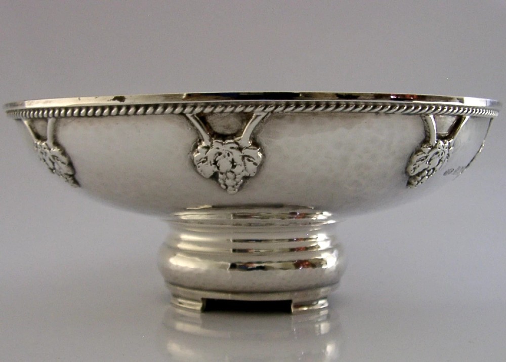 A hand-hammered sterling silver footed tazza featuring applied grape and vine motifs along the rim. View V