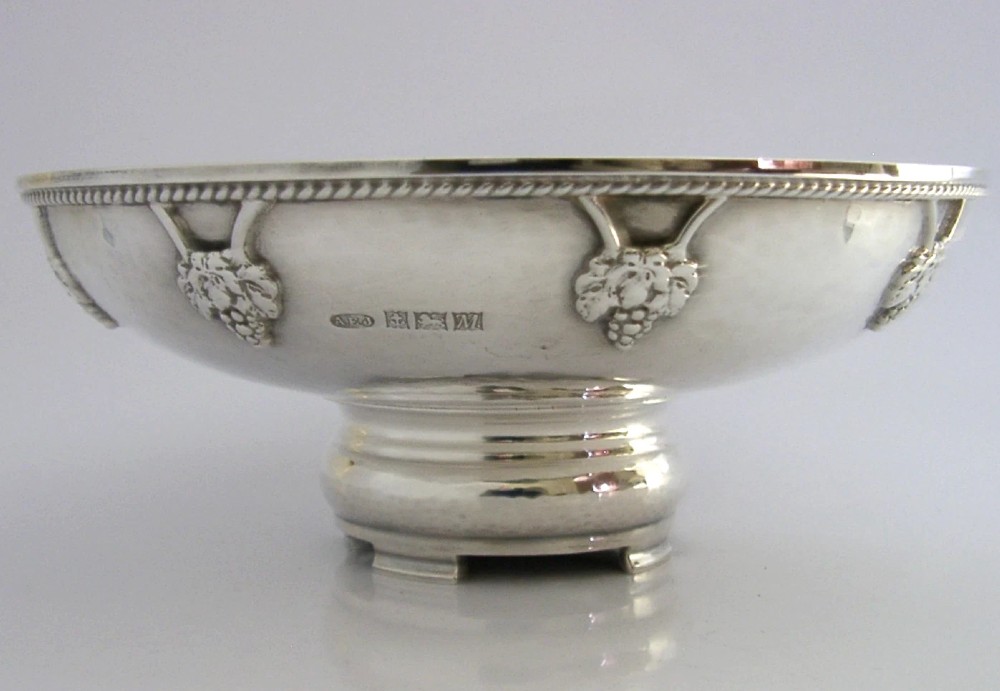 A hand-hammered sterling silver footed tazza featuring applied grape and vine motifs along the rim. View VII