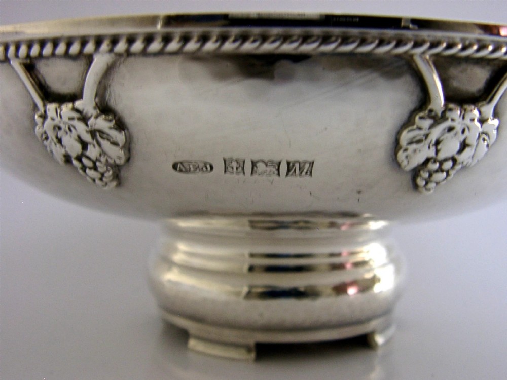 A hand-hammered sterling silver footed tazza featuring applied grape and vine motifs along the rim. View X