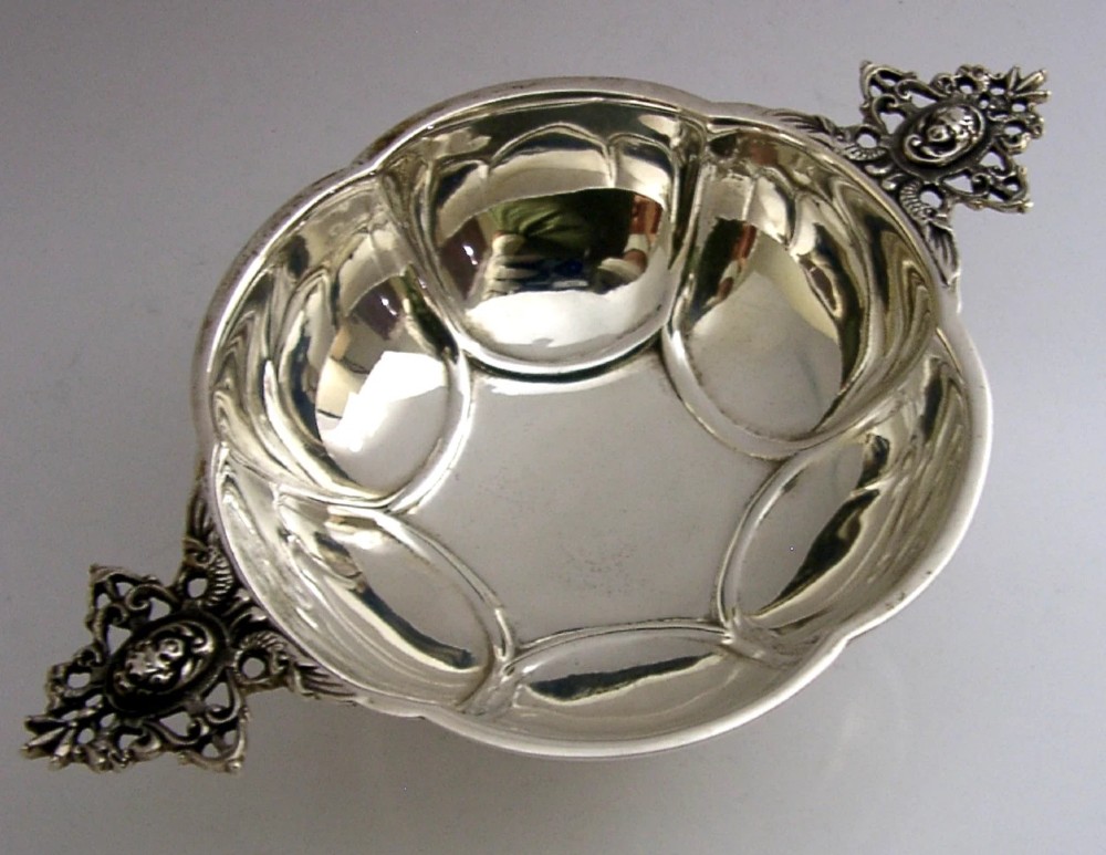 A Dutch solid silver lobed brandy bowl featuring twin ornate openwork cast handles with scrollwork details.