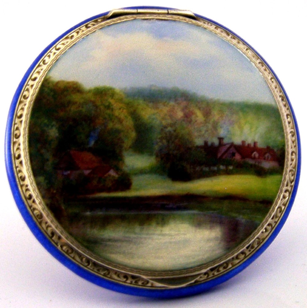 An open Art Deco sterling silver powder compact featuring a cobalt blue enamel rim and a hand-painted landscape scene on the lid interior. View III