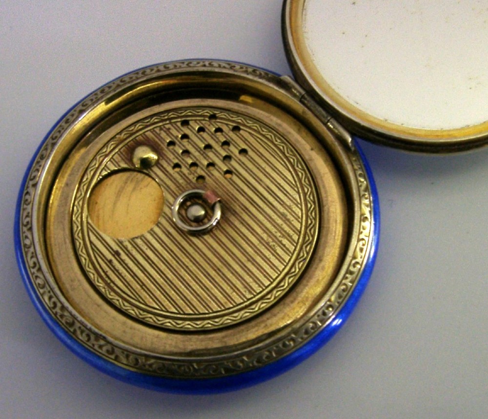 An open Art Deco sterling silver powder compact featuring a cobalt blue enamel rim and a hand-painted landscape scene on the lid interior. View IX