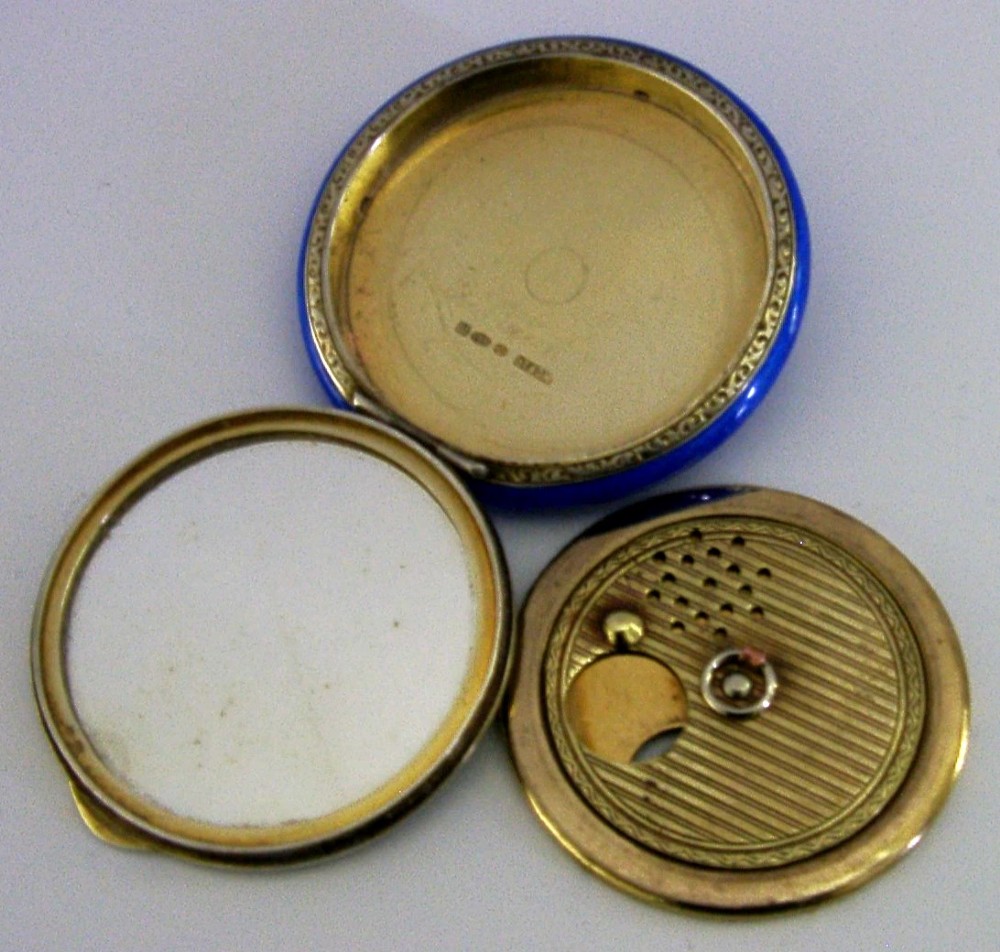 An open Art Deco sterling silver powder compact featuring a cobalt blue enamel rim and a hand-painted landscape scene on the lid interior. View XI