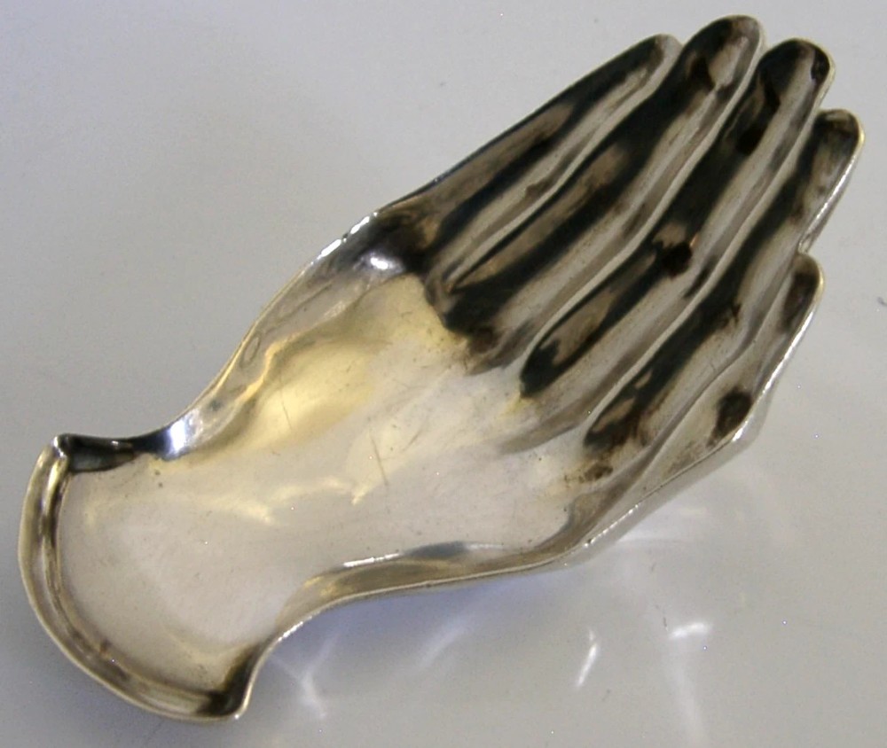 An Edwardian sterling silver tea caddy spoon crafted in the shape of a cupped human hand with an engraved monogram letter K and visible British hallmarks. View III